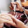 Manicurist using electric nail drill when removing old nail polish, selective focus