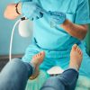 Professional doctor podiatrist holding electric modern device in the cabinet